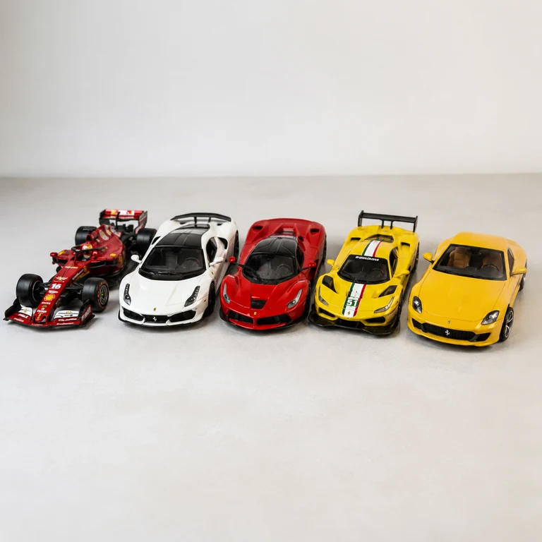 Coleção de cinco miniaturas Ferrari alinhadas sobre uma mesa.