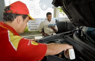 Frentista posto trocando óleo do carro